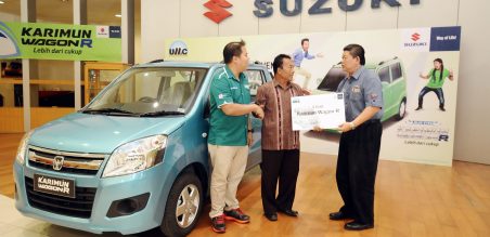 Prabowo Liegangsaputro, Direktur PT UMC (kanan) didampingi Stefanus Asiantara W, Area Representatif PT SIS wilayah Jatim saat secara simbolis memberikan hadiah Mobil Karimun Wagon R kepada Sarponen, pemenang grand prize kuis Suzuki