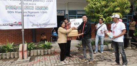 Indra Lubis, Marketing Planning TAM (kiri) secara simbolis memberikan donasi kepada Mardiningsih, ka sekolah SDN Klamis Ngasem 1/246 Surabaya