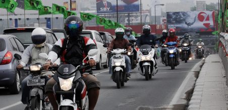 Pengendara bermotor melintas jalanan, Jumat(14/02) pagi saat debu vulkanik turun menyelimuti kota Surabaya