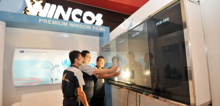 William Ler, Manager Lintec Advanced Graphics Industrial And Construction Materials(kiri) beserta Iwan Udaya, Direktur PT Krisant Pundimas Sejahtera(tengah) saat memperagakan katahanan kaca film Wincos dengan panas sorot lampu