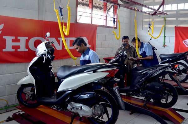 Disaksikan gurunya, siswa SMK Prakarya Internasional saat praktek penyetelan sepeda motor Honda, di bengkel praktek Teknik Sepeda Motor Honda SMK Prakarya Internasional