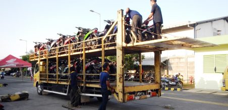 Kuli angkut sedang menata motor pemudik di dlam truk