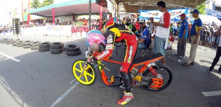 Seorang dragster memakai wearpack saat melakukan pemanasan sebelum start
