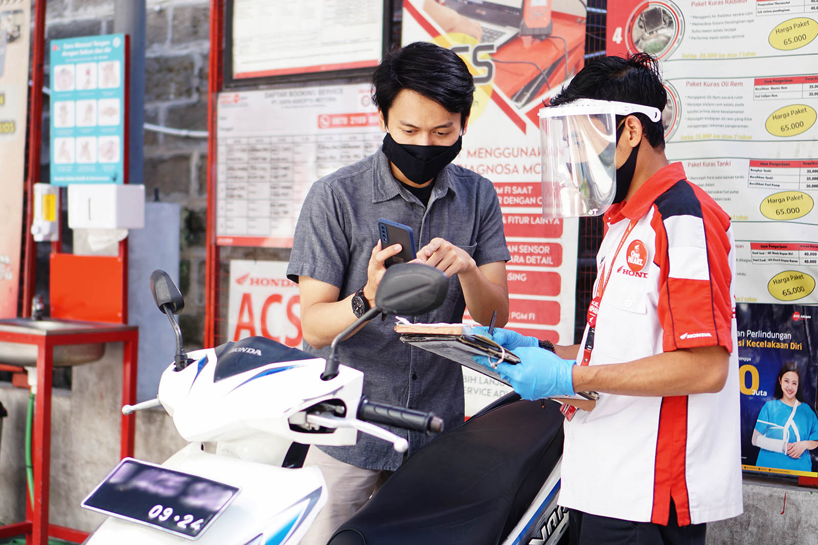 Konsumen sedang memperlihatkan booking service melalui aplikasi Daya Auto kepada Service Advisor (SA)